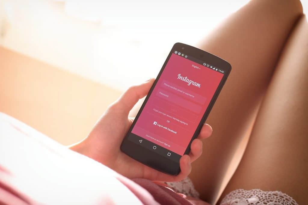 Title image for How To Increase Engagement On Instagram With The Instagram Growth Guide - woman using Instagram app on phone