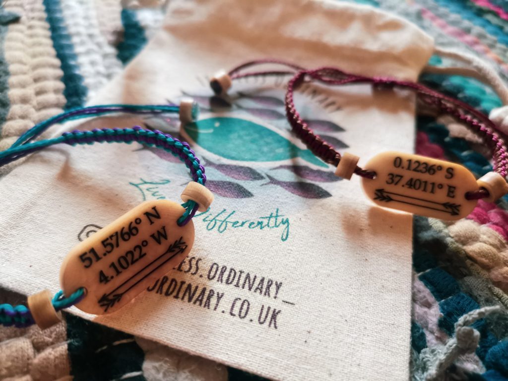 Two bracelets from Life Less Ordinary (one blue and purple, the other brown and burgandy) placed on a Life Less Ordinary jewellery pouch for vegan gift ideas